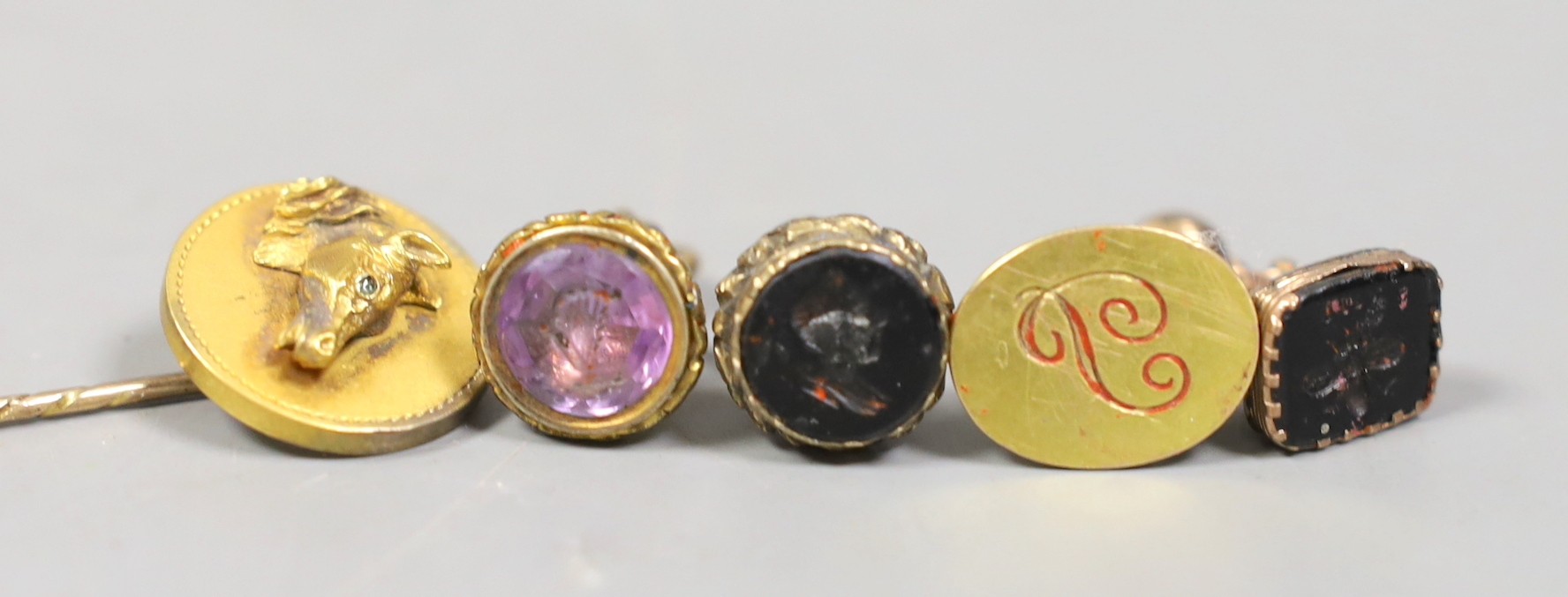 Three Victorian gilt metal fob seals, two set with bloodstone and carved with bust or bee, the other set with amethyst, a similar 9ct fob seal, a yellow metal horse head stick pin and a group of envelopes with wax seals.